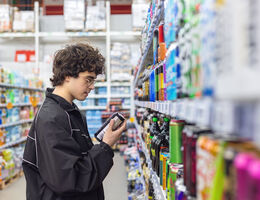 boy choosing beverage in supermarket