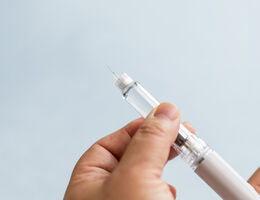 woman preparing a GLP-1 semaglutide injection pen at home.