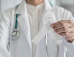 Physician holding white ribbon for lung cancer awareness 