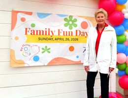 A colorful “Family Fun Day” banner displayed outdoors next to balloons at the event entrance.