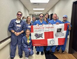 Cardiology team stand together in a hallway holding a large banner that reads “VARIPULSE Platform.” 