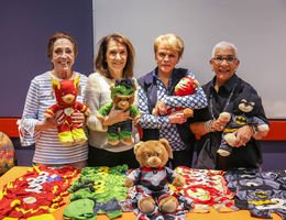 Pediatric patients gifted Build-A-Bears by Desert Guild four elderly women holding teddy bears