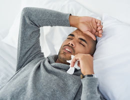 5 signs it’s more than a cold Man lying in bed with a headache
