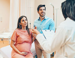 C-Section Births: OB-GYN expert weighs in Husband and wife talking to the doctor in the hospital
