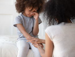 Here’s what to know about Sickle Cell Disease in kids mixed race mom comforts young daughter