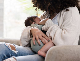 To breastfeed or not to breastfeed — is it safe if you have COVID-19? Sitting on a chair in her living room, the unrecognizable mom holds her baby snugly while breastfeeding him