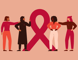 Four women of various races and ethnicities stand gathered around the breast cancer awareness ribbon