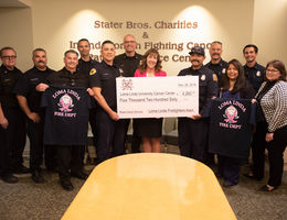 Loma Linda Firefighter’s Association raises $4,260 for breast cancer patients check and shirts being held by the crowd