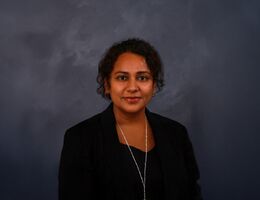 Indian woman with dark hair, black professional attire portrait headshot