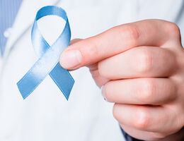Blue ribbon in doctor hand.