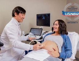 Caucasian woman with brown hair receives a prenatal ultrasound from a doctor of Asian decent