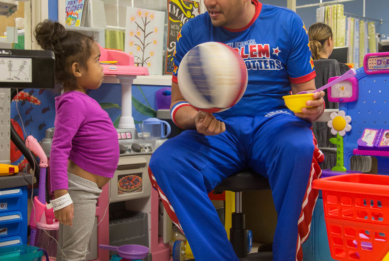 Harlem Globetrotter "El Gato" Melendez shows young cancer patient a spinning ball trick. The Harlem Globetrotters brought Valentine's Day cheer to children at the Loma Linda University Children's Hospital Hematology/Oncology Clinic on Wednesday, February 14, 2018, in Loma Linda, California.