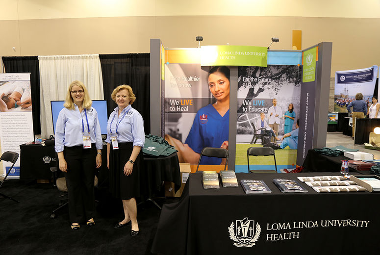 Elisa Blethen (left) and Janya Mekelburg staffing the Loma Linda University Health booth at the 2016 ASI convention in Phoenix, Arizona. 