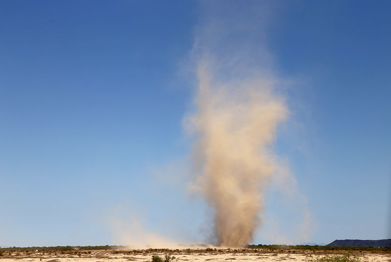 As if to highlight the extremes of summer weather in central Arizona, a dust devil churns a path between earth and sky near Vicksburg.