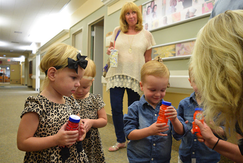 Courtney Martin, who helped care for Brittany during her pregnancy, hands out bubbles to the quadruplets—which became their focus for the rest of the visit.