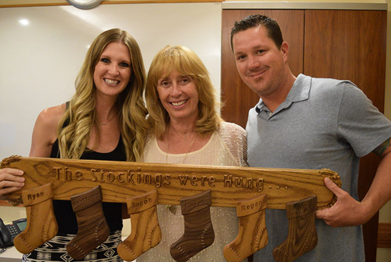 Brittany (left) and Ryan (right) accept a gift from night nurse Phyllis Zehmas, whose husband handcrafted it for the Stuit family.