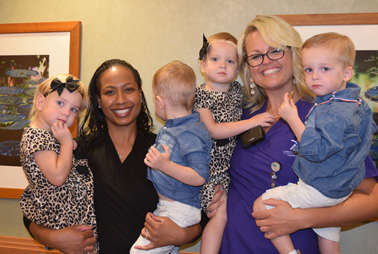 MFM specialist Shareece Davis-Nelson and obstetrician/gynecologist Courtney Martin take a turn at holding the quadruplets.