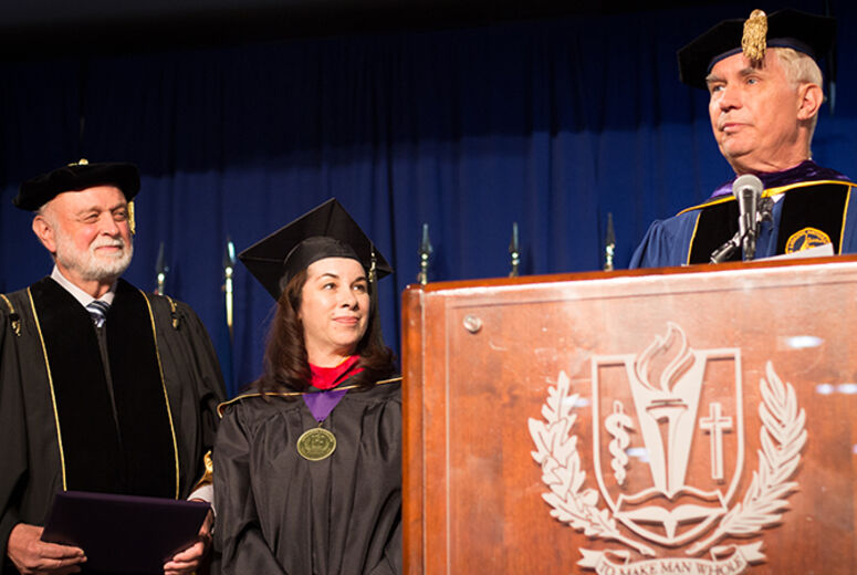 Flanked by President Richard Hart, MD, DrPH, and School of Religion Dean Jon Paulien, PhD, is an honored graduate.