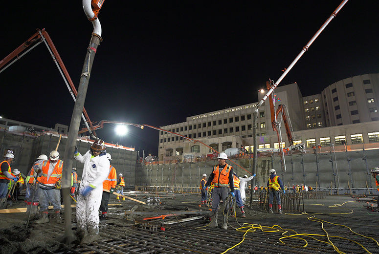 For more than 10 hours on Saturday night, March 25, concrete for the new hospital's foundation flowed down to workers. (photo by Cosmin Cosma) 