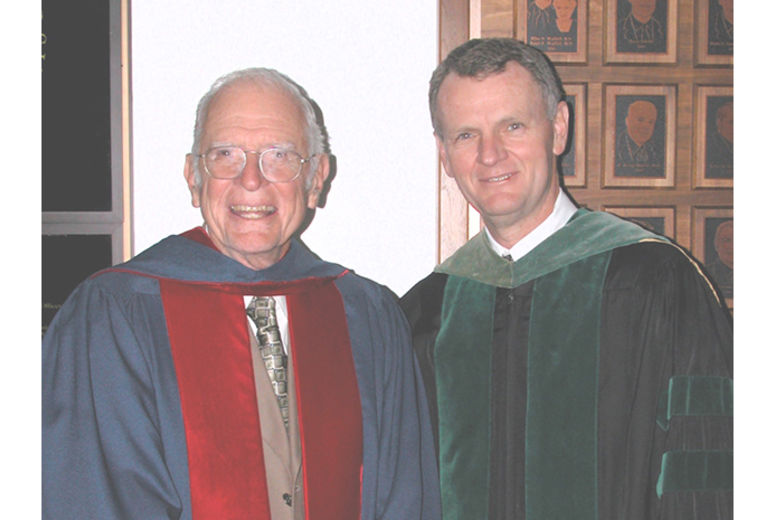 Louis Smith, MD, at left, received the University Distinguished Service Award in 2003 for starting organ transplantation at Loma Linda University Health and for mentoring generations of future doctors, including Roger Hadley, MD (right), dean of the School of Medicine. They are shown in academic regalia for the graduation ceremony in which Smith accepted his award.