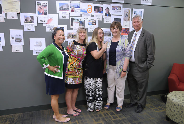 Colleagues and friends of Carlene Drake gathered in front of a timeline that captures both advances in technology and milestones in Drake’s life.